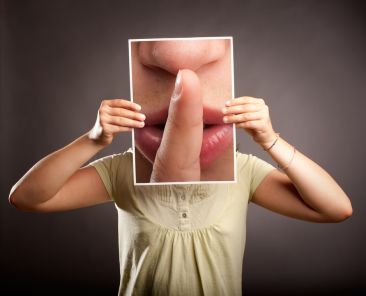 young girl showing silence gesture on a gray background